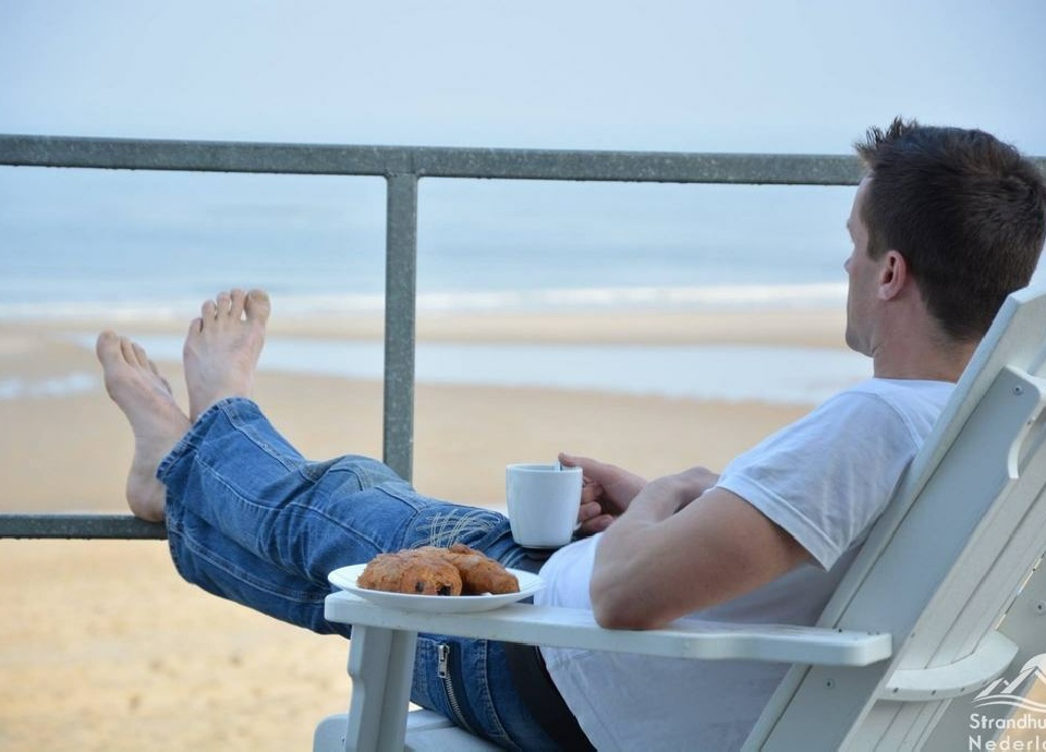 Nathan Ultee op het strandterras van een strandhuisje